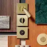 Brass modern switches set and decorative hardware display with geometric shapes and textured panels.