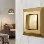 Luxury gold light switch on marble wall, hinting at what makes switches luxury quality with brass craftsmanship and premium design.