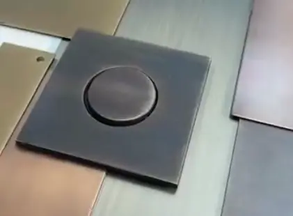 Square brushed metal switch plate with a centred circular push button, surrounded by assorted metallic swatches. Square brushed metal switch plate with a centred circular push button, surrounded by assorted metallic swatches.