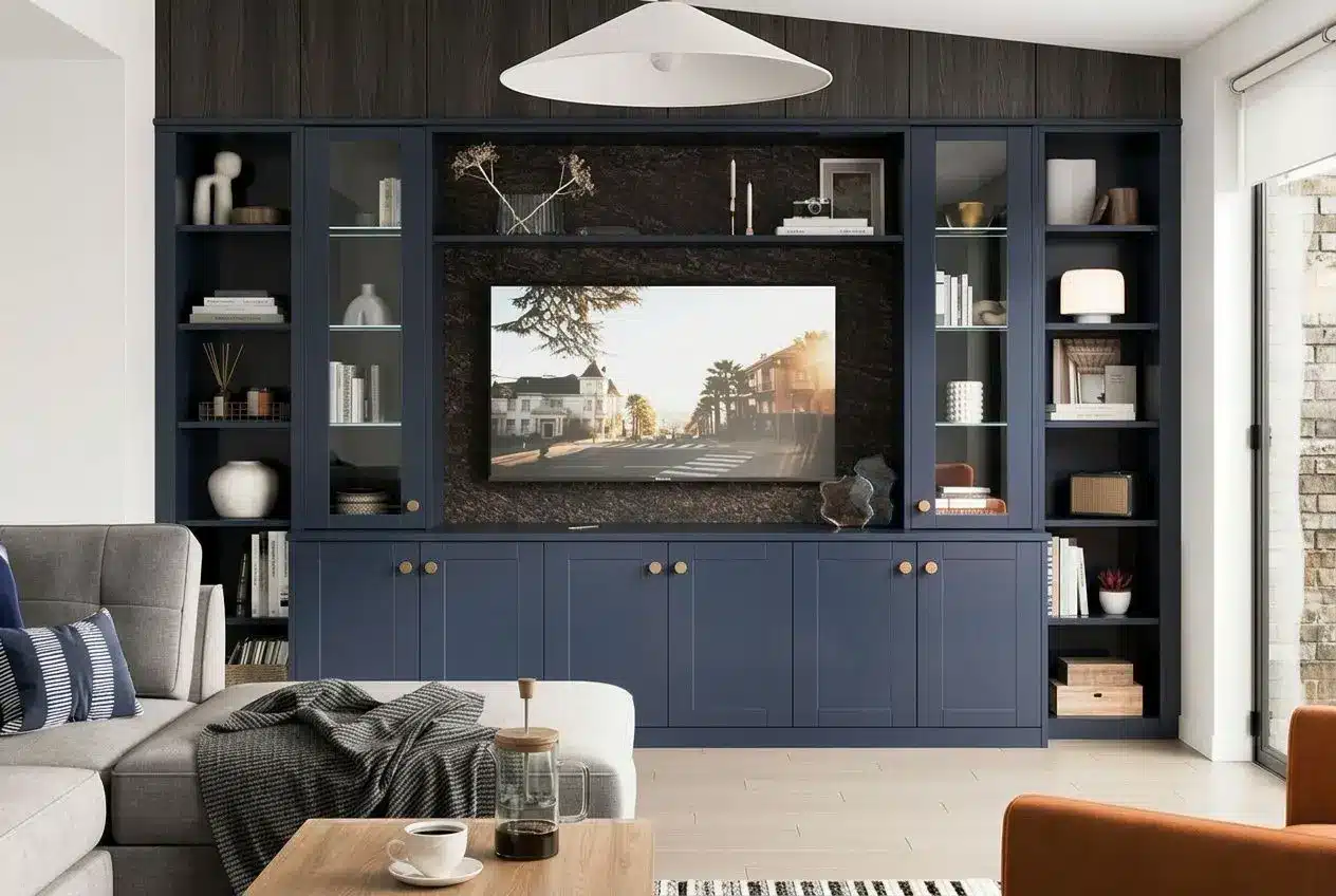 Living room with a dark blue built-in media unit and shelves around a wall-mounted TV, neatly concealing sockets; stylish décor and a cosy seating area. how to hide plug sockets in living room